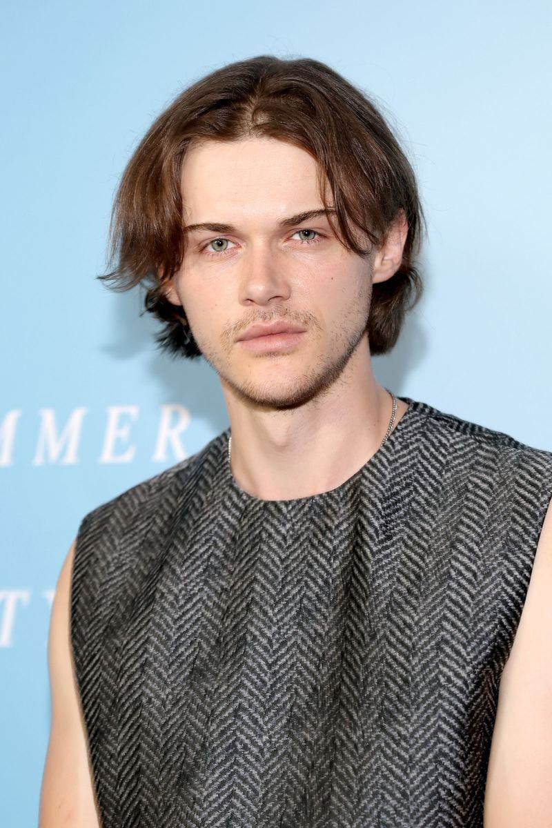 Man with medium-length wavy hair, low fade, and textured layers framing face