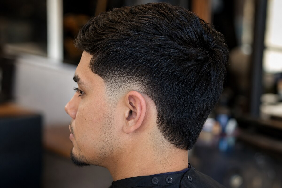 Compact burst taper fade with a soft curved blend behind the ear and natural neckline