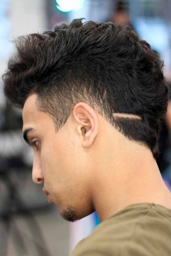 Dense thick textured hair with internal layers and a high-contrast burst fade around the ear