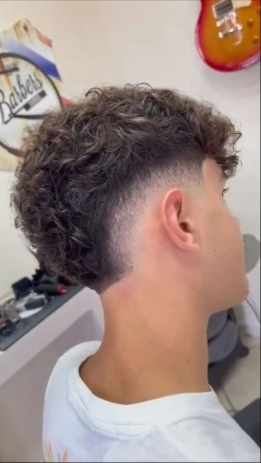 Layered wavy hairstyle with a mid burst fade wrapping around the ear