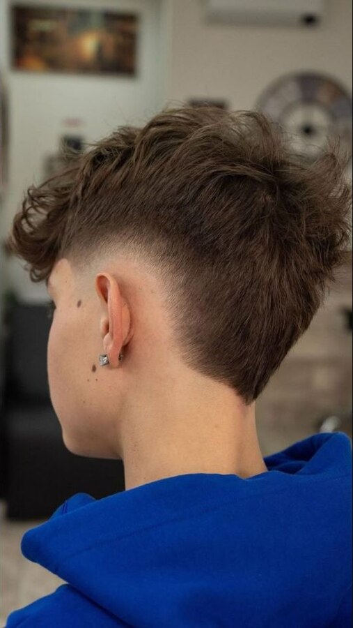 Short fine textured hair with a subtle low burst taper curving behind the ear