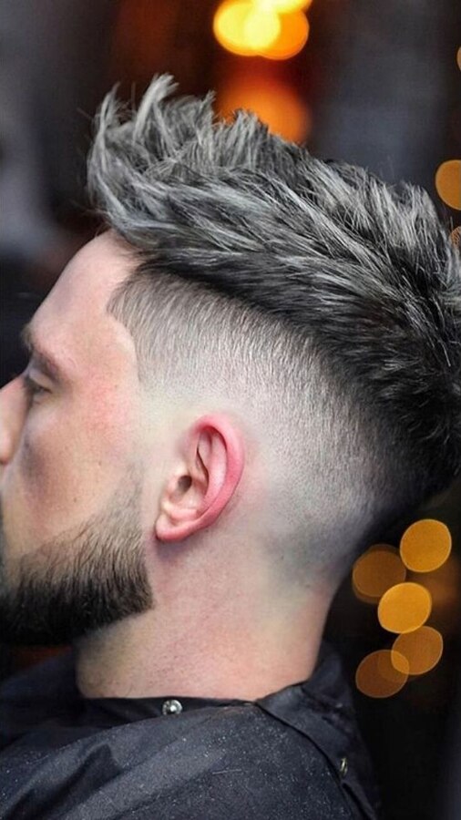 Short irregular spikes with a mid to high burst fade forming a semicircle behind the ear