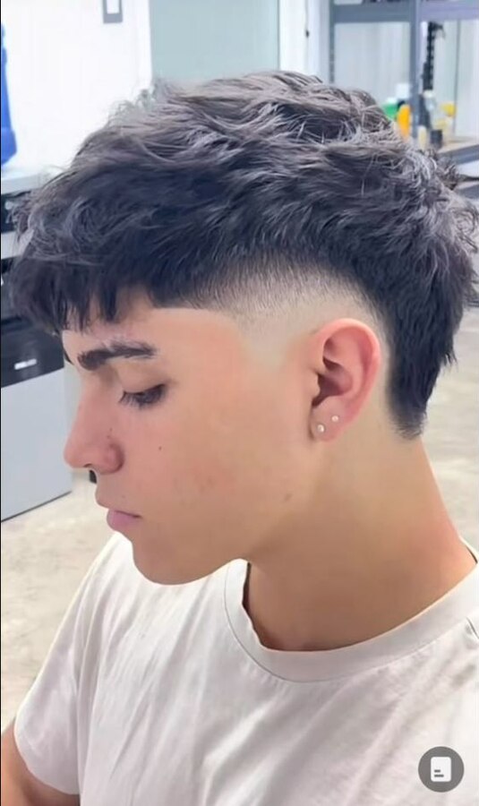 Straight textured hair with a clearly defined semicircular burst fade behind the ear